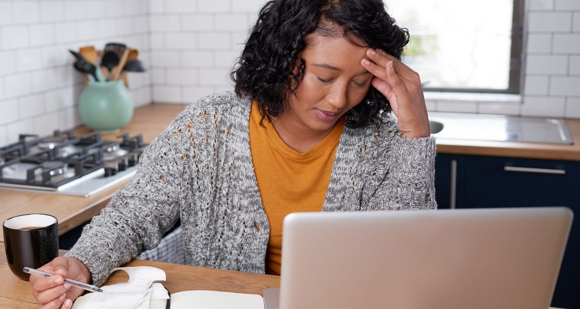 A young multi-ethnic woman is stressed while calculating household expenses