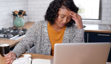 A young multi-ethnic woman is stressed while calculating household expenses