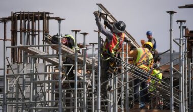 Construction workers work at the site of a condo tower under construction, in Delta, B.C., on Wednesday, July 2, 2025. Six months after U.S. President Donald Trump