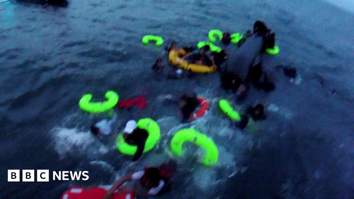 Yellow and red life-bands in the sea as people try and cling on to them. The picture is slightly blurry as it has been taken from a bodyworn camera.