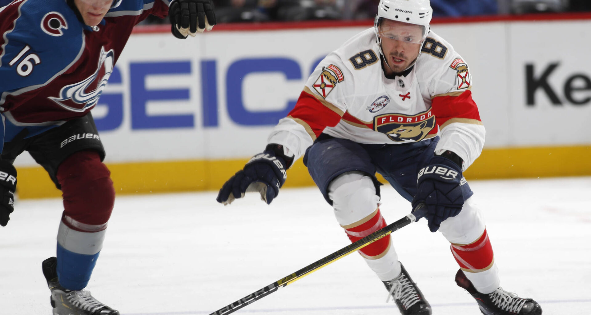 Former Florida Panthers centre Jayce Hawryluk, right, reaches out to control the puck as Colorado Avalanche defenceman Nikita Zadorov pursues during a National Hockey League game on Feb. 25, 2019 in Denver. Hawryluk now plies his trade in Europe. (Associated Press)