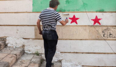 A man paints Syria's flag on a wall as U.S. President Donald Trump announced that he would order the lifting of sanctions ...