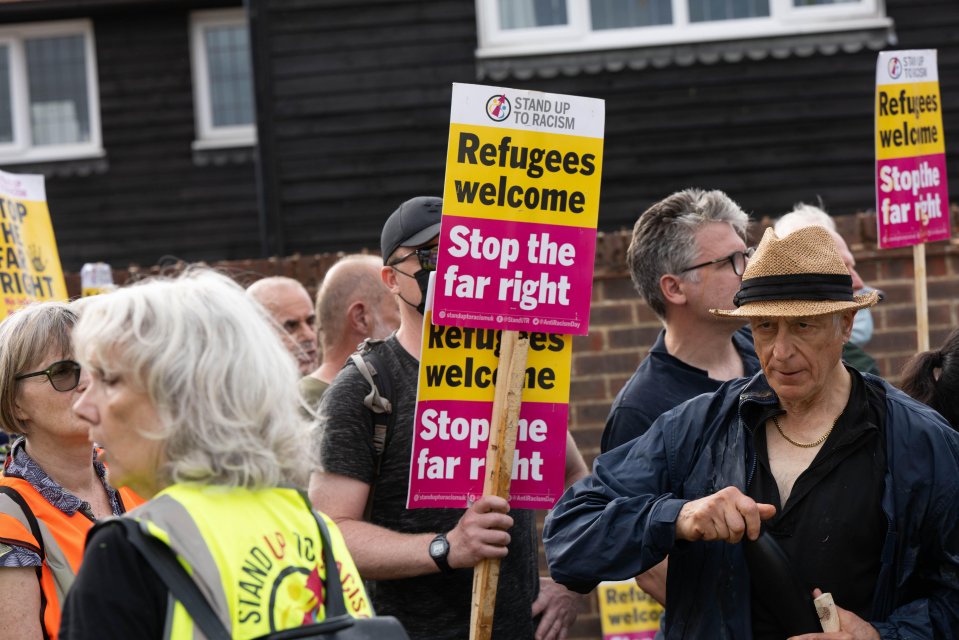 Pro-immigrant protesters holding signs that read "Refugees welcome" and "Stop the far right."