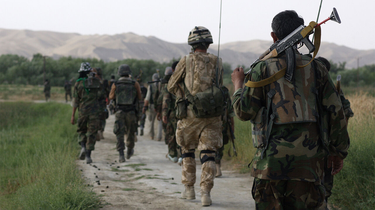 A British army officer patrols with Afghan soldiers in Sangin Valley, Helmand Province, Afghanistan, June 2007