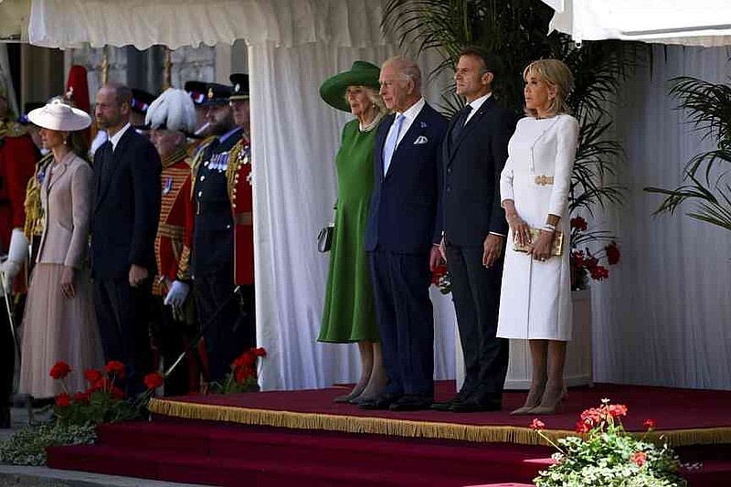 Britain's King Charles III, Queen Camilla, French President Emmanuel Macron, second left, and his wife Brigitte Macron, right, attend a welcome ceremony, in Windsor, England, Tuesday July 8, 2025, on the first day of a three-day state visit to Britain. (Dylan Martinez/Pool via AP)