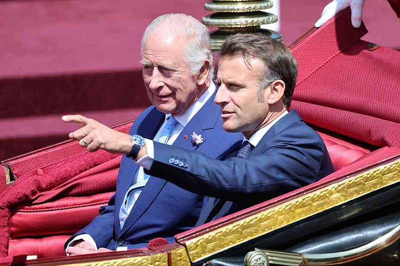 Britain's King Charles III and France's President Emmanuel Macron, right, travel in a 1902 State Landau on a state drive to Windsor Castle in Windsor, England, Tuesday July 8, 2025, on the first day of a three-day state visit to Britain. (Chris Jackson/Pool via AP)