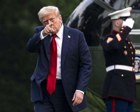 US President Donald J Trump points after exiting Marine One on the South Lawn of the White House in Washington DC.