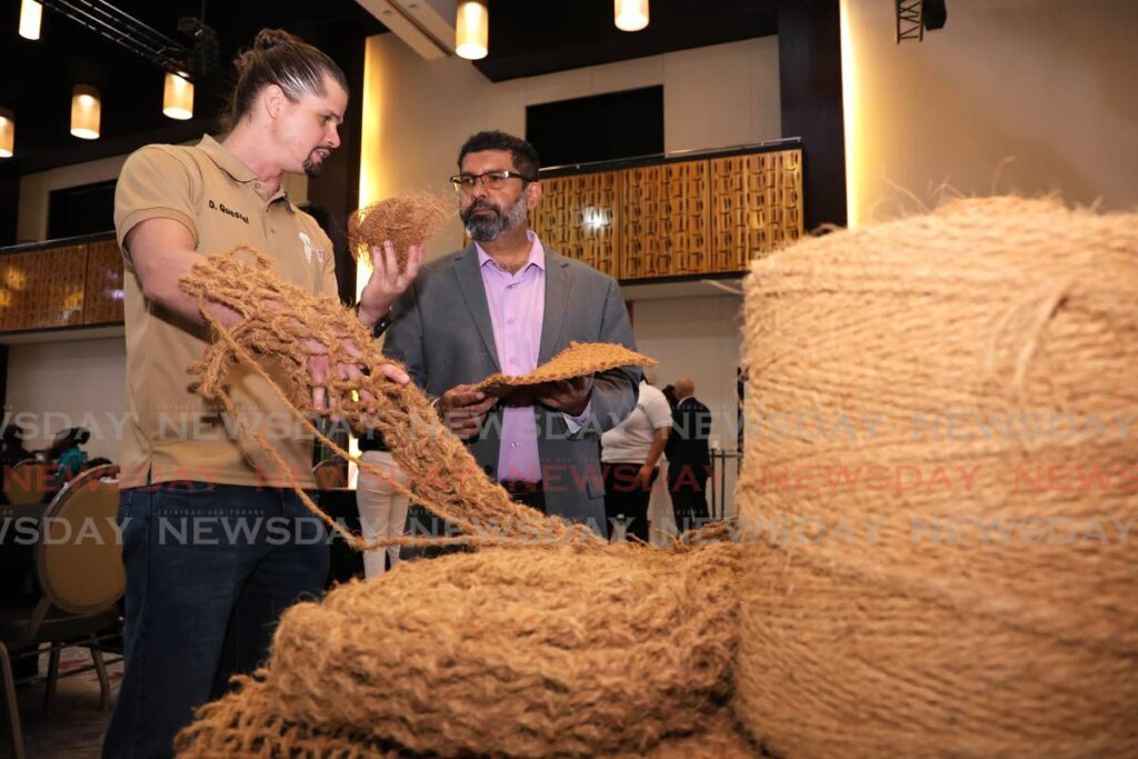 David Quesnel of VetiverTT Ecological Engineering Solutions Ltd speaks with Crisen Maharaj of Global TT about eco-friendly rope and mattting made of coconut husk fibres at Cariri's Shaping the Future of Innovation grant awards ceremony at Hyatt Regency, Port of Spain, on June 25.  - Photo by Faith Ayoung