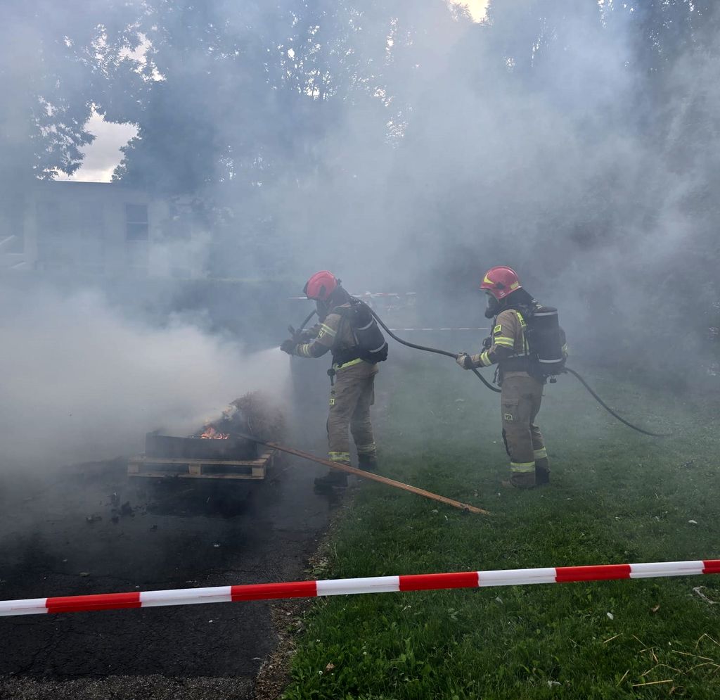 strażacy w czasie gaszenia ognia 