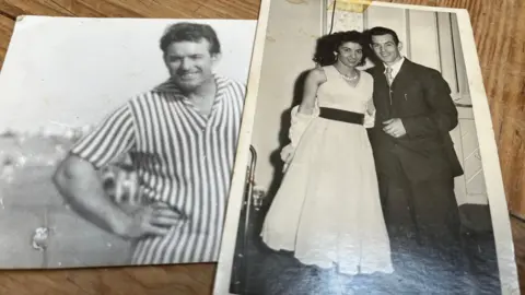 Steven Benavente Two photos on a table. They are both black and white images. The one on the left has a man smiling and wearing a striped top and the one on the left is of a couple on what seems to be their wedding day. She has a white dress on and he has a dark suit on. 