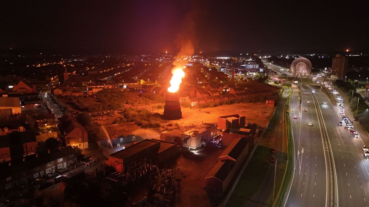 Firefighters work to protect an electricity sub station as a Controversial bonfire at Meridi Street, off the Donegall Road in Belfast is lit. Picture: Niall Carson/PA Wire