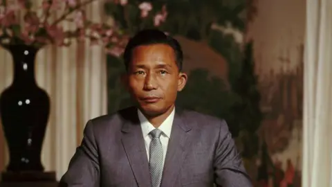Getty Images Park Chung-hee standing in front of a painting a flower vase
