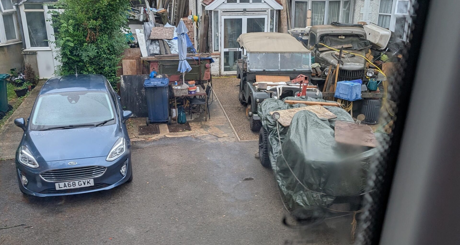 Does anyone know what these vehicles are is this house in North London? I see it everyday on my commute and it looks 1950s America military trucks. But what's that doing in a semi in North London?