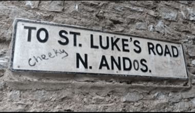 A cheeky road sign graffito.