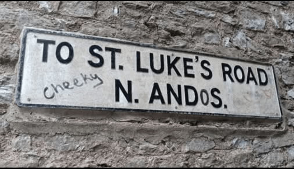 A cheeky road sign graffito.