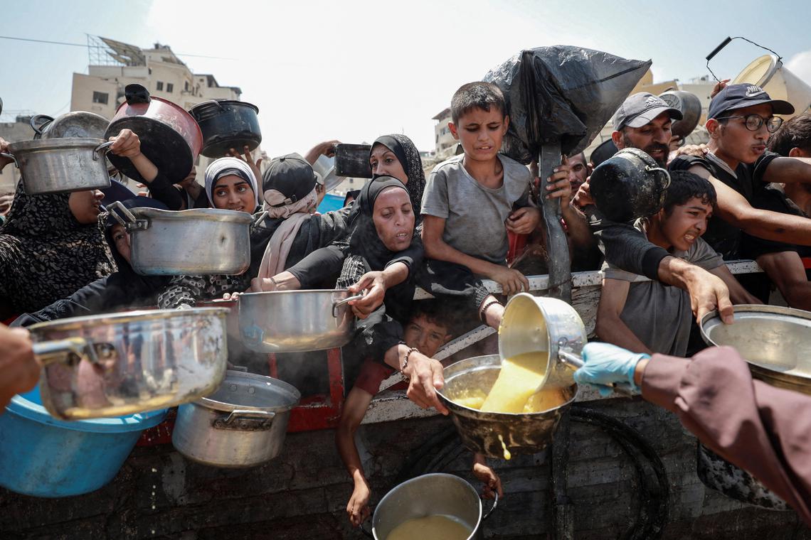 Palestinians gather to receive food from a charity kitchen in Gaza on July 28.