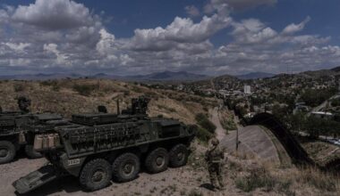 A man is halted climbing the US-Mexico border wall. Under new Trump rules, US troops sound the alarm