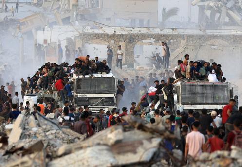 Des Palestiniens montent sur des camions transportant de l’aide humanitaire, à Beit Lahya, dans le nord de la bande de Gaza, le 29 juillet 2025.