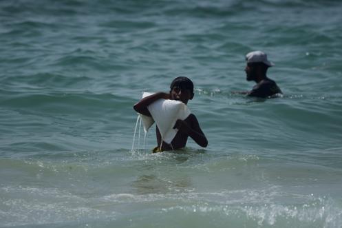 Un jeune Gazaoui porte un sac d’aide humanitaire qui a atterri dans la mer Méditerranée après avoir été largué par avion au-dessus du centre de Gaza, sur la côte d’Al-Zawayda, dans la bande de Gaza, mardi 29 juillet 2025.