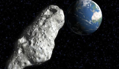 A gray rocky asteroid heads back toward Earth in the darkness of space