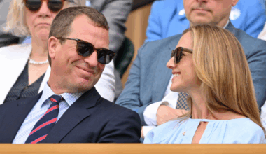 Peter Phillips and Harriet Sperling smiling at each other at Wimbledon wearing sunglasses