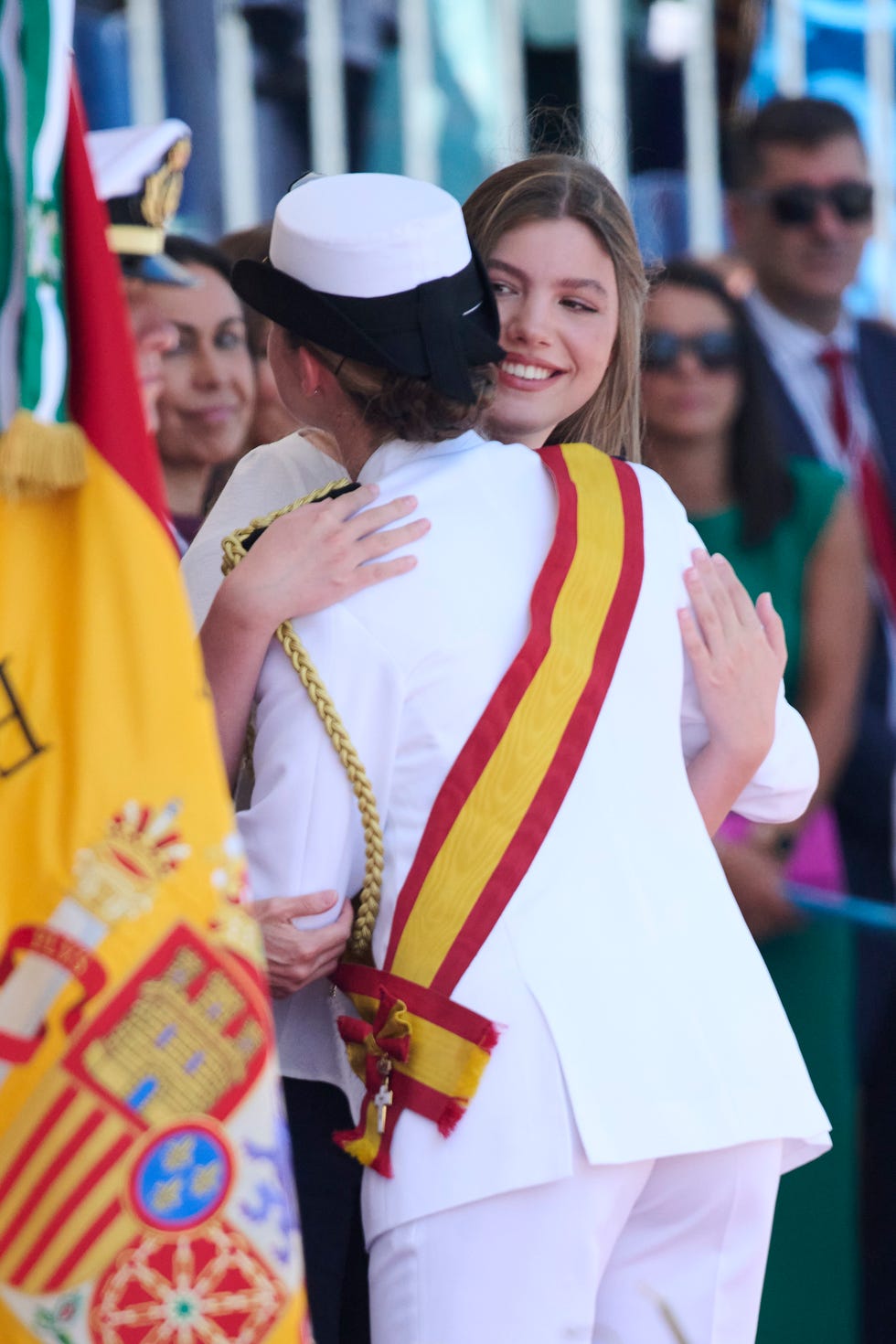 Ceremony featuring individuals in formal attire embracing.