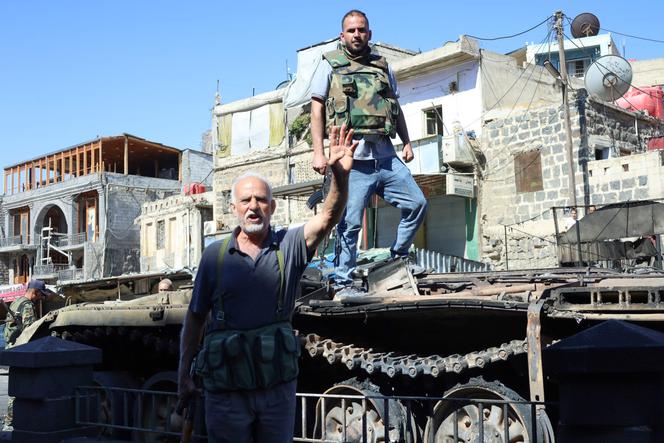 Druze fighters celebrate the withdrawal of the Syrian government's armed forces from the southern city of Sweida, on July 17, 2025.
