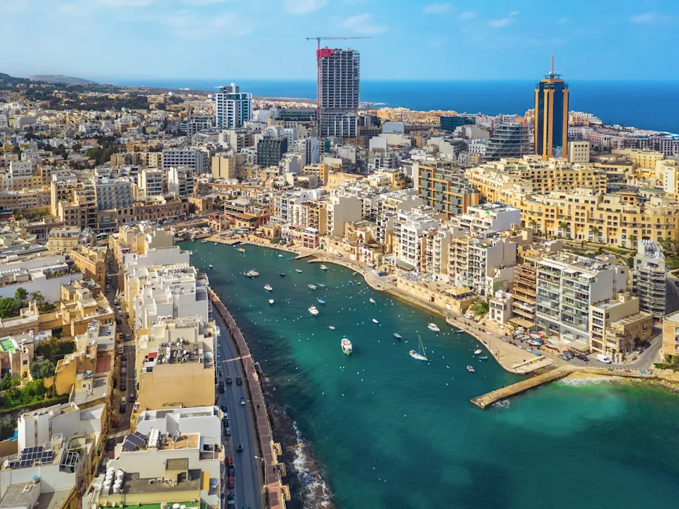 An aerial view of a city with a turquoise bay.