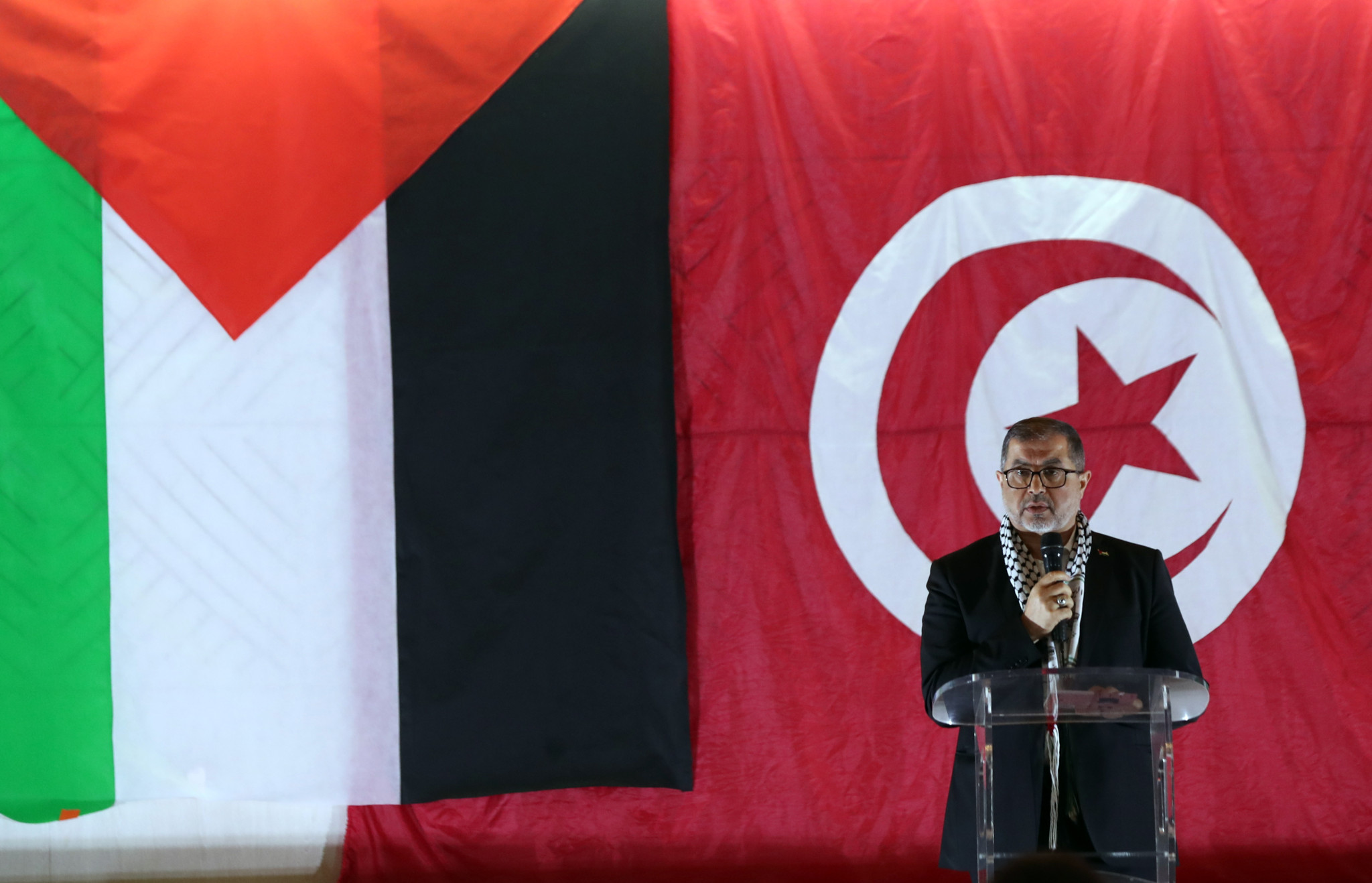Basem Naim du bureau politique du Hamas s’exprime lors du Forum tunisien pour soutenir la résistance palestinienne à Tunis, devant les drapeaux palestinien et tunisien. Basem Naim du bureau politique du Hamas s’exprime lors du Forum tunisien pour soutenir la résistance palestinienne à Tunis, devant les drapeaux palestinien et tunisien.
