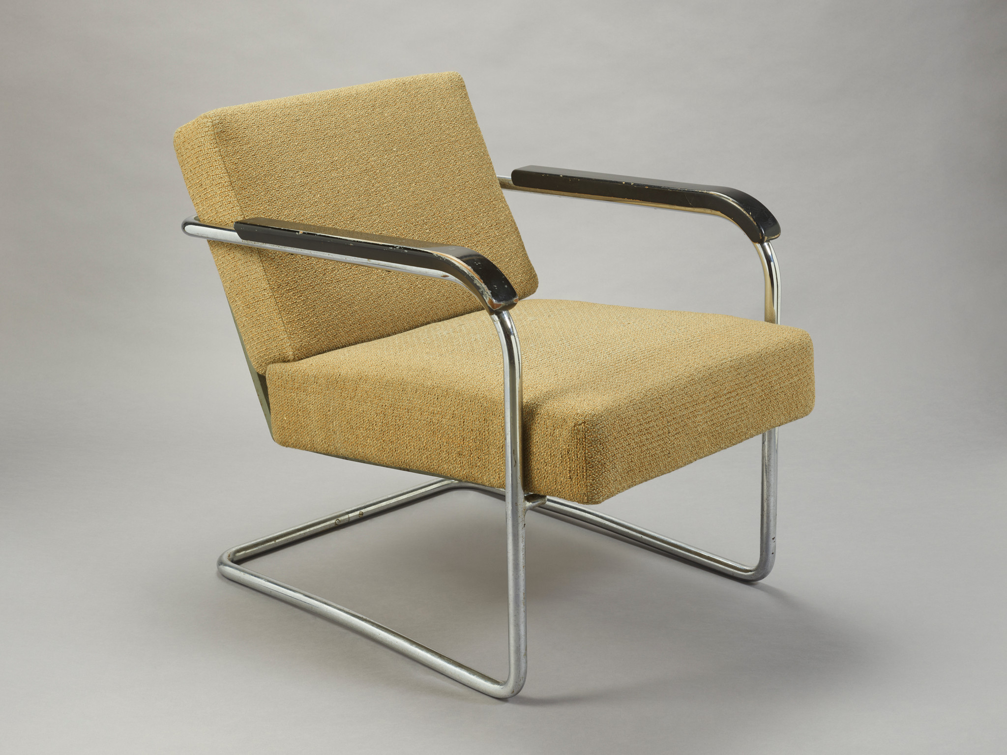 Fauteuil rétro à cadre métallique avec coussins beige, accoudoirs noirs et design moderne.