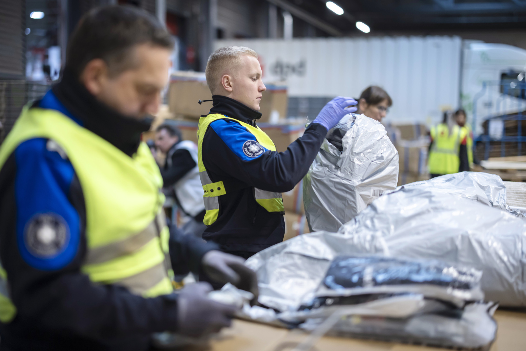 Des employés des douanes ouvrent des colis lors d’un contrôle ciblé du commerce en ligne transfrontalier au centre de colis DPD à Buchs, le 12 novembre 2024.