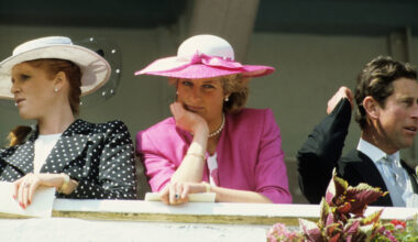 Princess Diana wearing a pink blazer and white hat resting her chin on her hand at the 1987 Epsom Derby next to Sarah Ferguson in a black polka dot coat and Prince Charles in a suit
