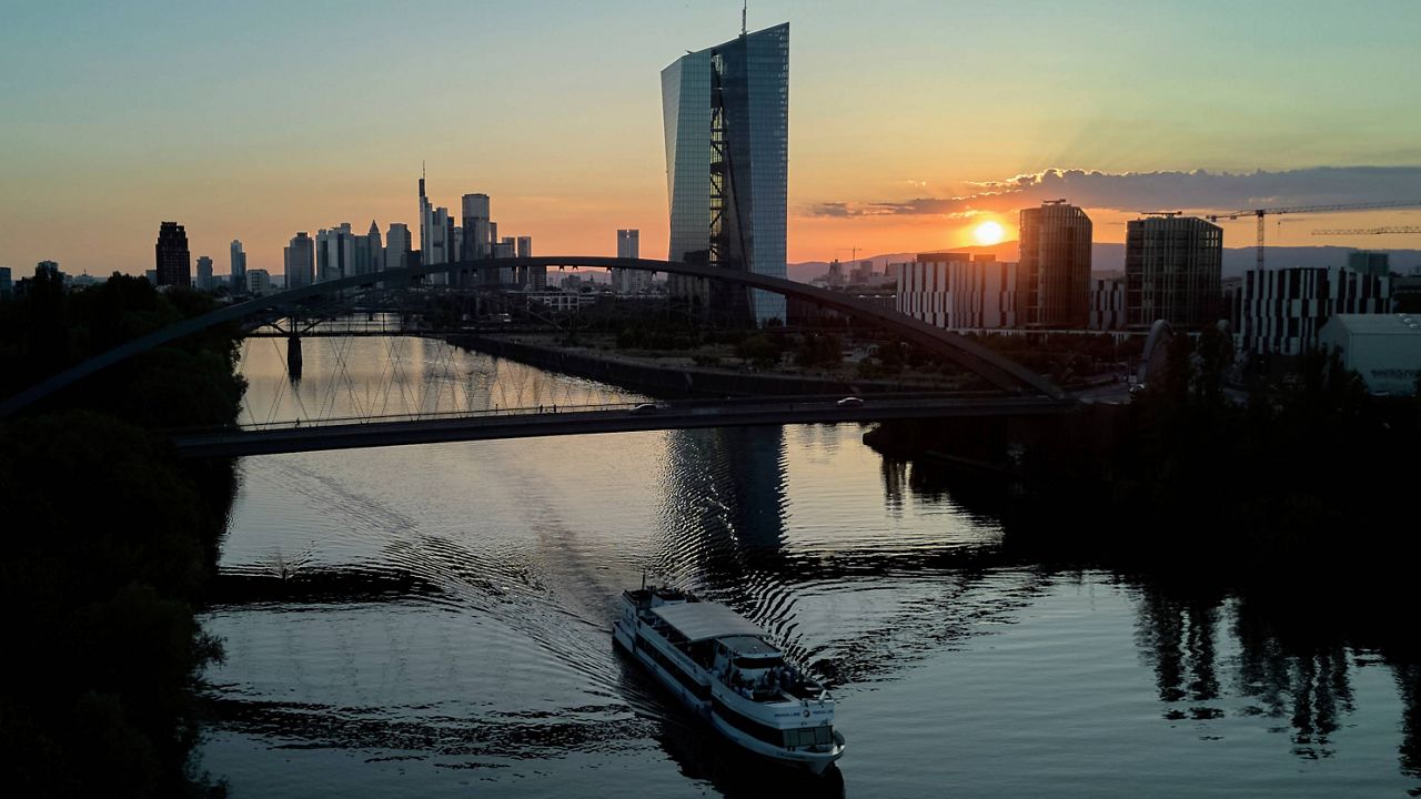 The sun sets behind the European Central Bank, right, and the buildings of the banking district in Frankfurt, Germany, Tuesday, July 1, 2025. (AP Photo/Michael Probst, file)