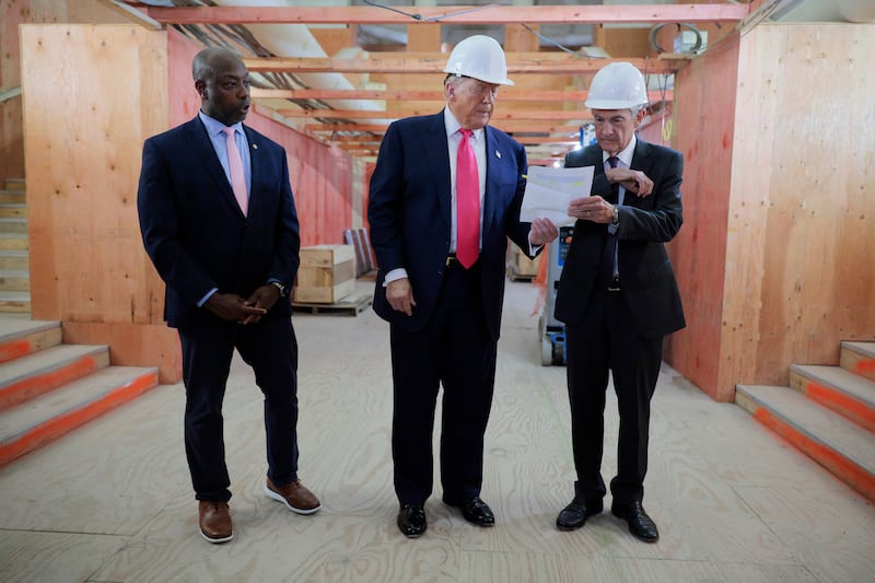 Donald Trump presents Federal Reserve chair Jerome Powell with what Mr Trump called a list of cost overruns for the Federal Reserve’s $2.5 billion headquarters renovation project during a tour with Republican senator Tim Scott in Washington, DC. Photograph: Chip Somodevilla/Getty Images