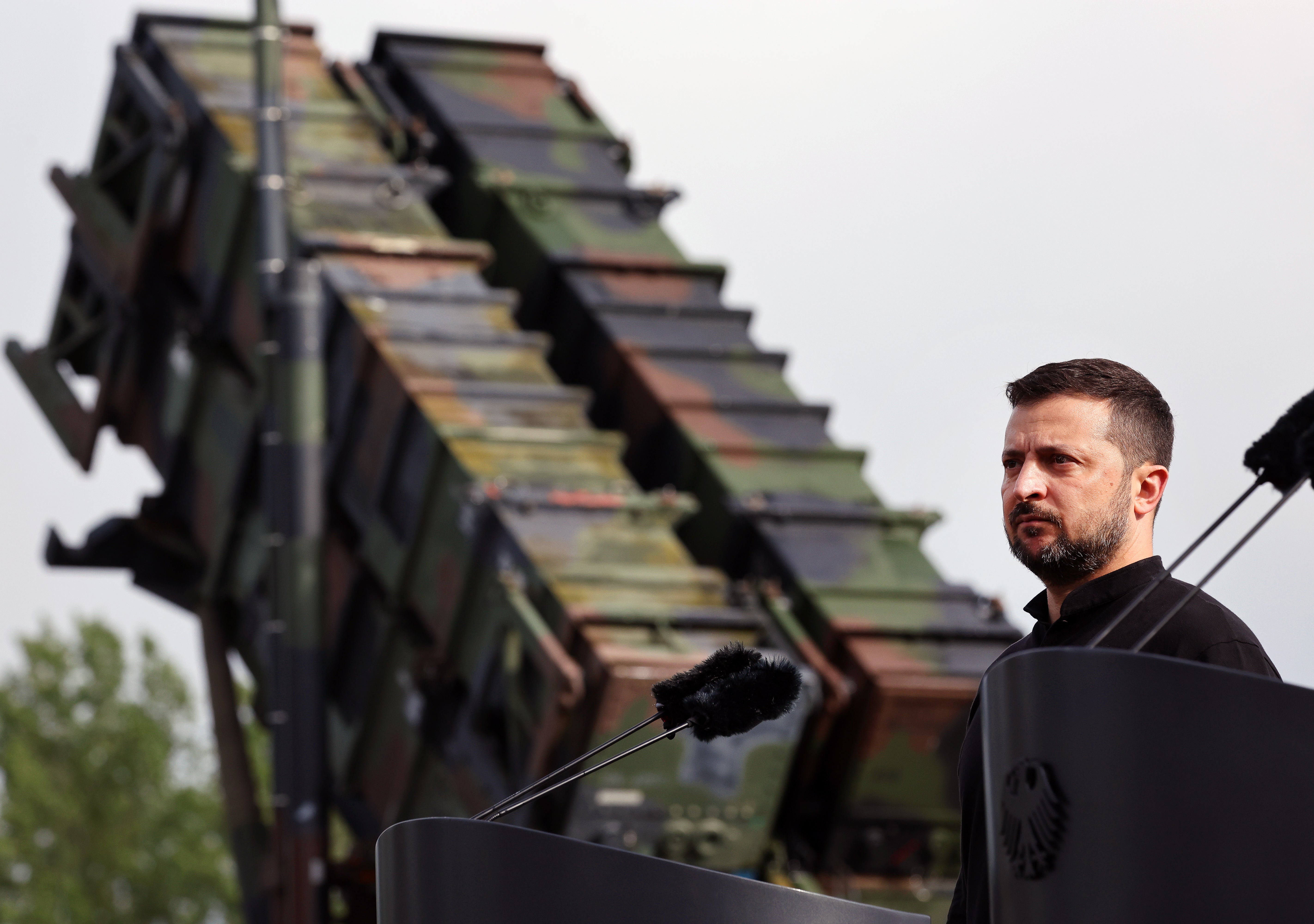 Volodymyr Zelensky stands in front of a Patriot anti-aircraft missile system during his visit to a military training area in Germany