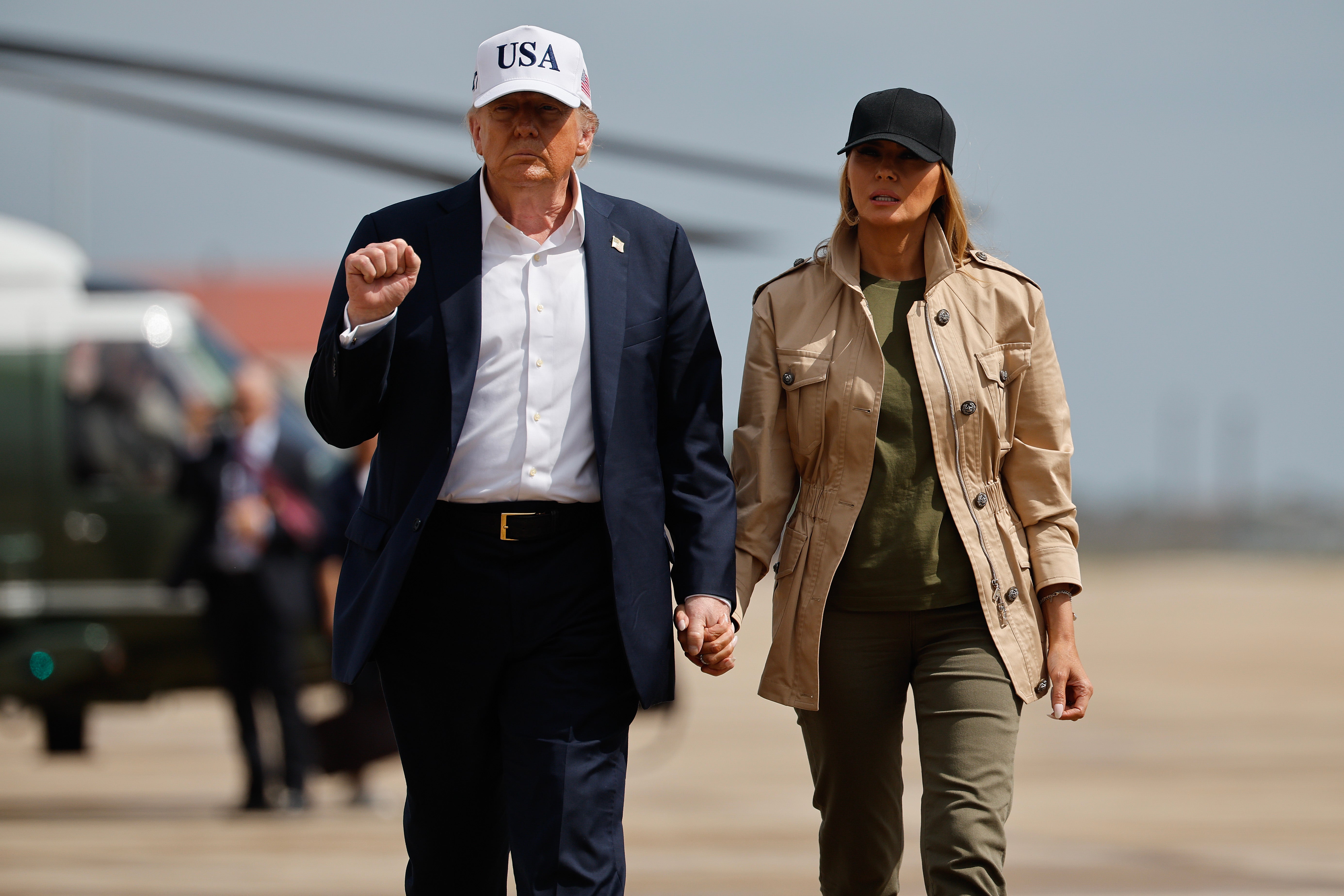 President Donald Trump and first lady Melania Trump visit walk across the tarmac at Lackland Air Force Base after meeting with state and local leaders, first responders and victims of last week's flash flooding on July 11 in San Antonio, Texas