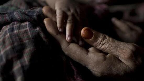IA Rohingya woman holds her baby boy's hand at a refugee camp in Bangladesh. (AP FILE/REPRESENTATIVE IMAGE)