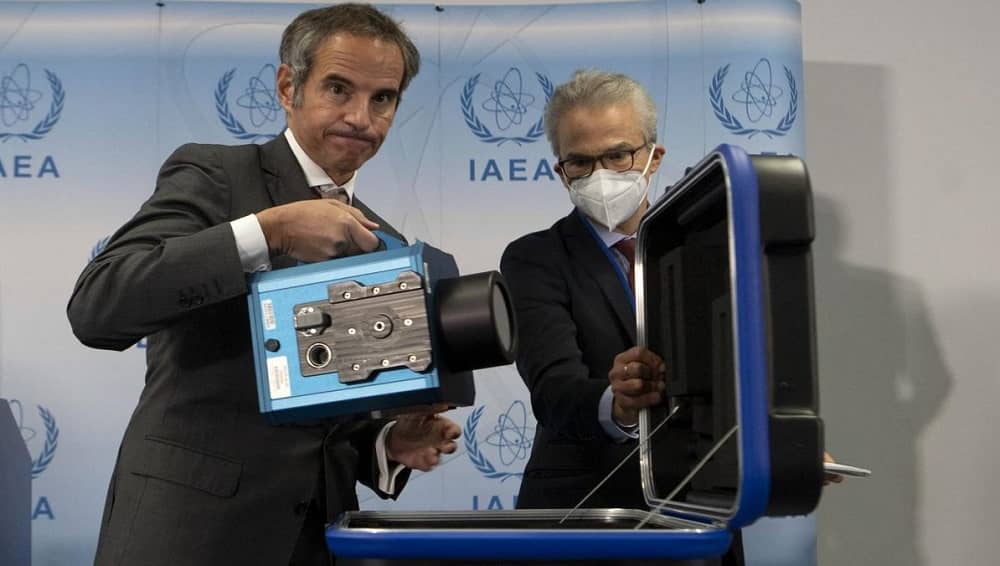 IAEA Director General Rafael Grossi demonstrates a surveillance camera used to monitor nuclear sites