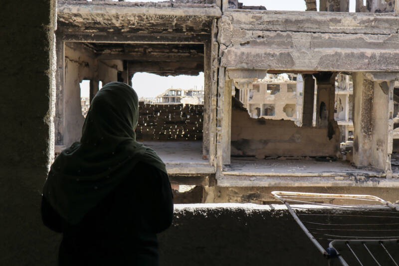 Zahir Klash, 41, looks out from the window of her home, 30/4/2025 (Natacha Danon/Syria Direct)
