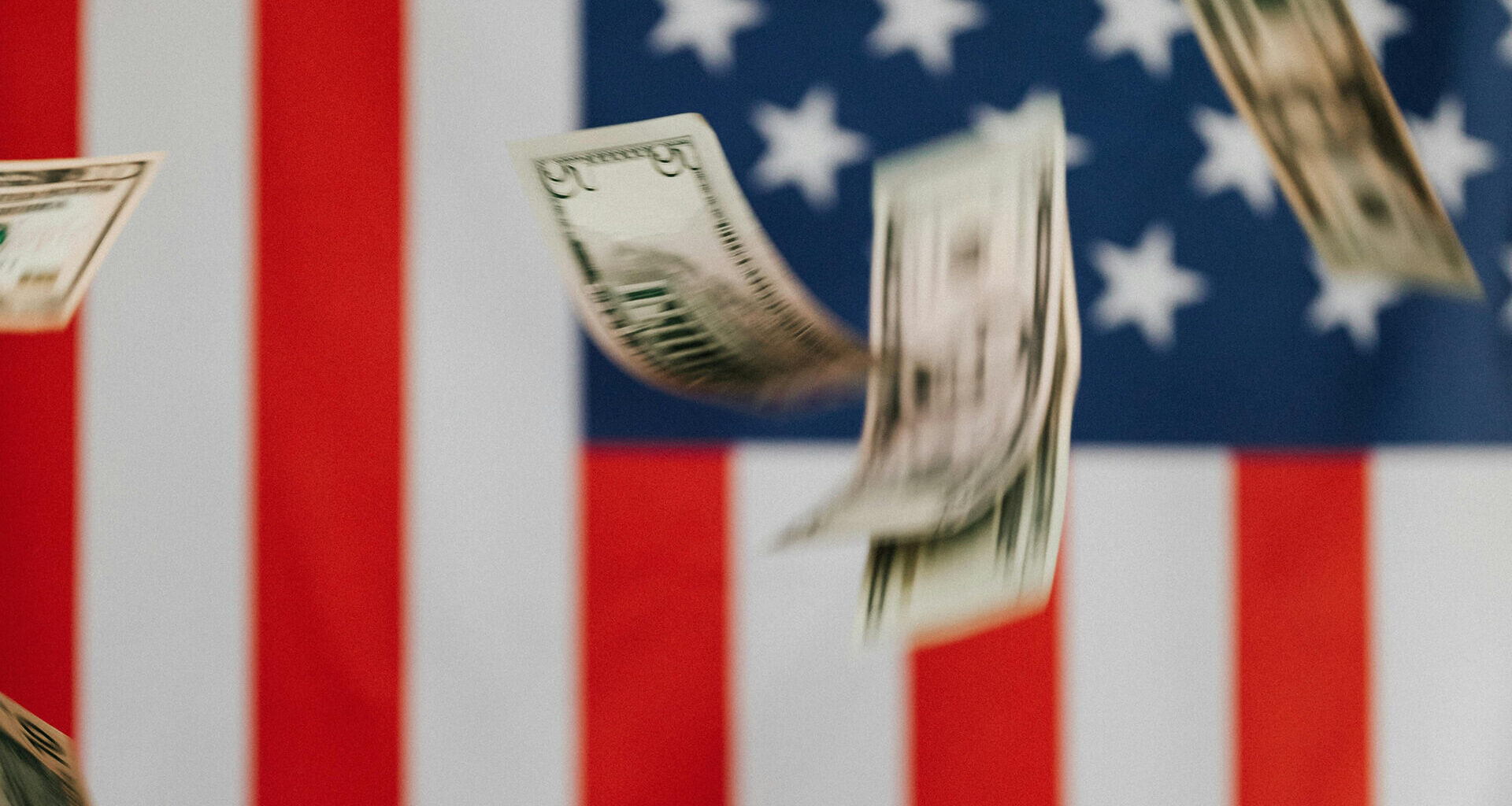 Photo of dollars behind American flag