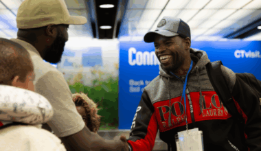 Staff from JFS of Western Massachusetts greet a refugee family at an airport.