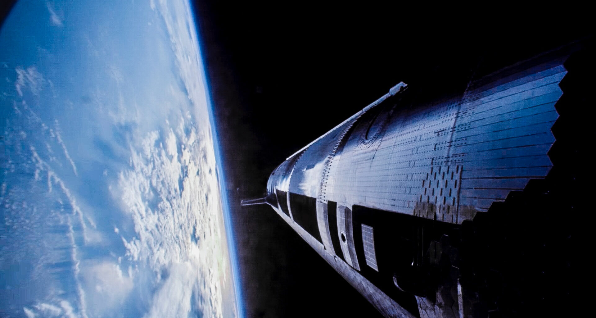 a huge cylindrical silver spacecraft flies above earth