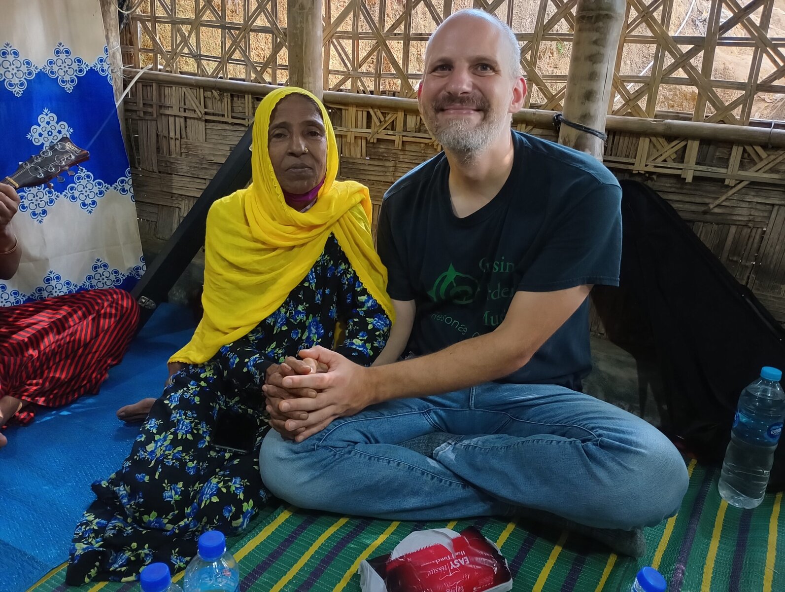 Rohingya refugee musician Kamal Mustafa sits with Crossing Borders Music co-director Tom Clowes.