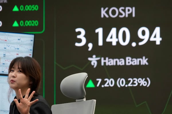 A currency trader works near a screen showing the Korea Composite Stock Price Index (KOSPI) at the foreign exchange dealing room of the KEB Hana Bank headquarters in Seoul, South Korea, Thursday, July 10, 2025. (AP Photo/Ahn Young-joon)