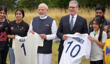Britain's PM Keir Starmer (R) and his Indian counterpart Narendra Modi hold shirts with their names as they meet school children at Chequers near Aylesbury.