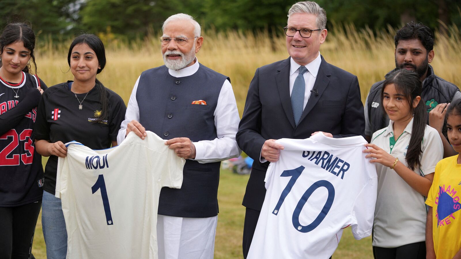 Britain's PM Keir Starmer (R) and his Indian counterpart Narendra Modi hold shirts with their names as they meet school children at Chequers near Aylesbury.