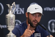 Scottie Scheffler of the United States gestures as he speaks at a press conference, with the...