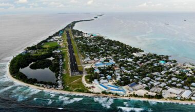 FUNAFUTI, TUVALU - NOVEMBER 28: An aerial view of downtown and the airport runway, between the Pacific Ocean (L) and lagoon (R), on November 28, 2019 in Funafuti, Tuvalu. The??low-lying??South Pacific island nation??of about 11,000 people has been classified as ???extremely vulnerable??? to climate change by the??United Nations Development Programme.??The world???s fourth-smallest country is struggling to cope with climate change related impacts including five millimeter per year sea level rise (above the global average), tidal and wave driven flooding, storm surges, rising temperatures, saltwater intrusion and coastal erosion on its nine coral atolls and islands, the highest of which rises about 15 feet above sea level. In addition, the severity of cyclones and droughts in the Pacific Island region are forecast to increase due to global warming. Some scientists have predicted that Tuvalu could become inundated and uninhabitable in 50 to 100 years or less if sea level rise continues.??The country is working toward a goal of 100 percent renewable power generation by 2025 in an effort to curb pollution and set an example for larger nations. Tuvalu is also exploring a plan to build an artificial island. (Photo by Mario Tama/Getty Images)