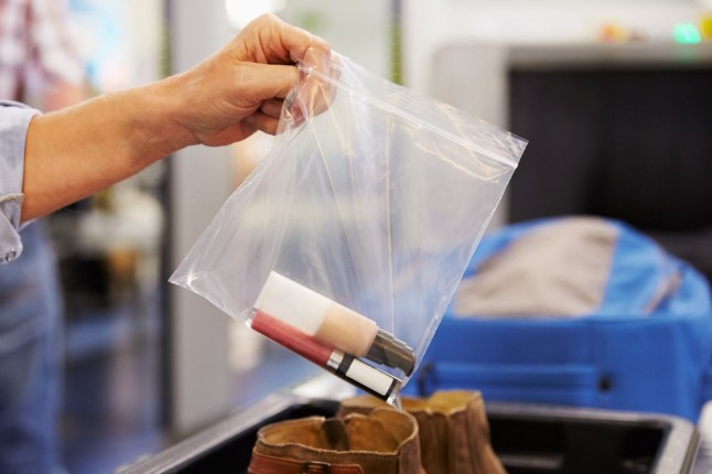 Passenger putting their liquid items into a plastic bag at airport security.