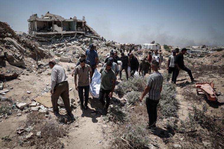 GAZA CITY, GAZA - JULY 15: Bodies of Palestinians, who were killed in an Israeli airstrike targeting the house of the Azzam family at the Sheikh Acclin neighborhood in the southern Gaza Strip, are brought to a private cemetery for burial in Gaza City, Gaza, on July 15, 2025. Relatives mourn their loved ones following the attack that claimed the lives of 19 Palestinians. (Photo by Khames Alrefi/Anadolu via Getty Images)